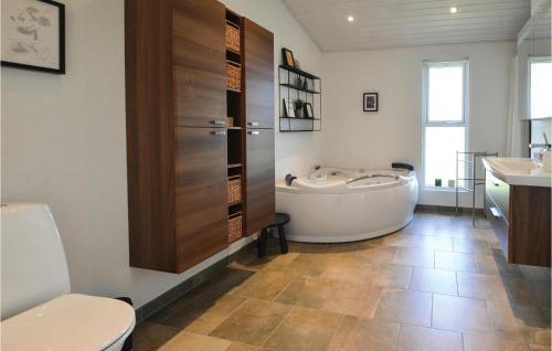 uma casa de banho com uma banheira, um WC e um lavatório. em Amazing Home In Ebeltoft With Kitchen em Ebeltoft