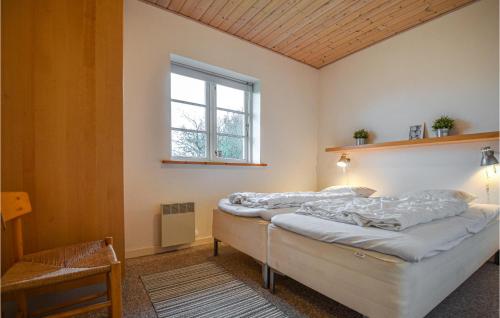 エーベルトフトにあるAwesome Home In Ebeltoft With 4 Bedrooms, Sauna And Wifiのベッドルーム1室(ベッド2台、窓付)