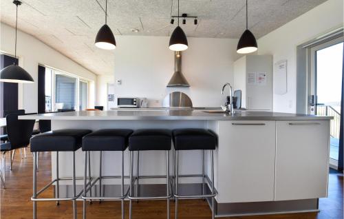 スナーヴィグにあるHoliday Home Ringkobing Xxxixのバースツール付きの大きな島のあるキッチンが備わります。
