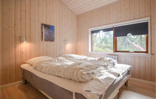 ein Schlafzimmer mit einem Bett mit einer Bettdecke und einem Fenster in der Unterkunft 4 Bedroom Gorgeous Home In Ebeltoft in Øksenmølle