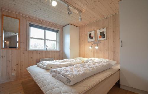 Schlafzimmer mit Holzwänden und einem Bett mit weißer Bettwäsche in der Unterkunft Cozy Home In Ebeltoft With Sauna in Ebeltoft