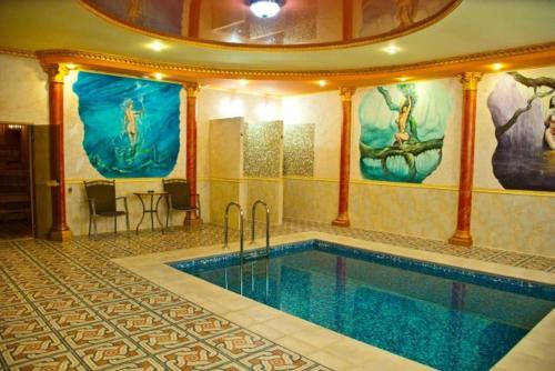 a large swimming pool in a building with a pool at Coliseum in Khmelnytskyi