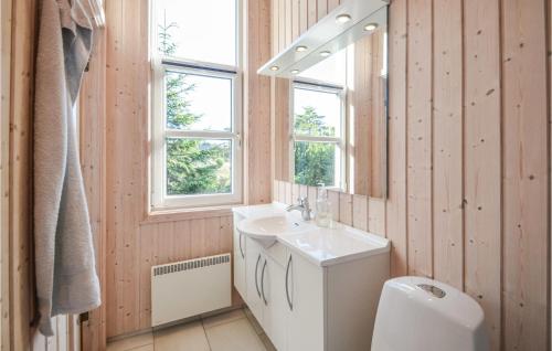 a bathroom with a sink and a toilet and a mirror at Beautiful Home In Fjerritslev With 4 Bedrooms, Sauna And Wifi in Fjerritslev