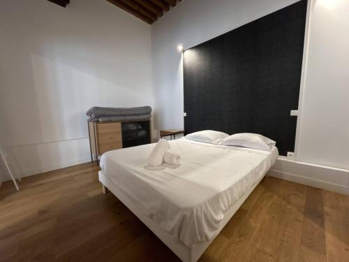 - une chambre avec un grand lit blanc et une tête de lit noire dans l'établissement Cosy appt cœur de Lyon du Bœuf 3, à Lyon