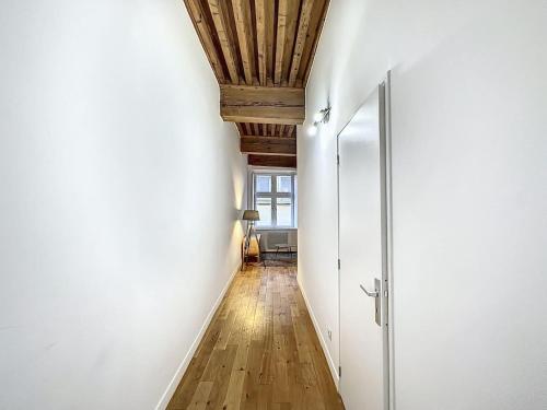 un couloir avec des murs blancs et un plafond en bois dans l'établissement Cosy appt cœur de Lyon du Bœuf 3, à Lyon