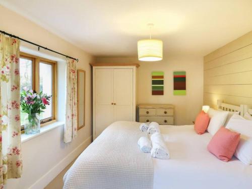 a bedroom with two beds and a window at Luggs Barn - Beautiful Devon Hideaway in Hemyock