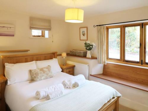 a bedroom with a white bed with towels on it at Luggs Barn - Beautiful Devon Hideaway in Hemyock