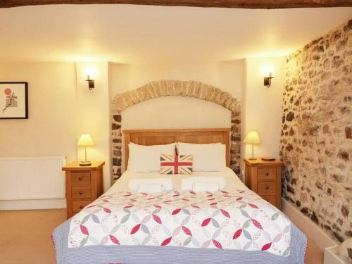 a bedroom with a large bed and two night stands at Luggs Barn - Beautiful Devon Hideaway in Hemyock
