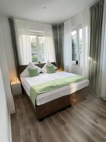 um quarto com uma cama grande num quarto com janelas em Fewo am Wiesengrund em Lüdinghausen