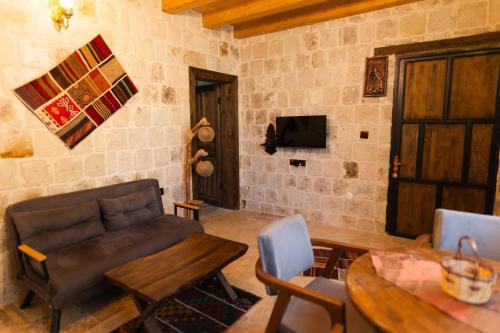 un soggiorno con divano e tavolo di Cappalace Stone House a Ürgüp