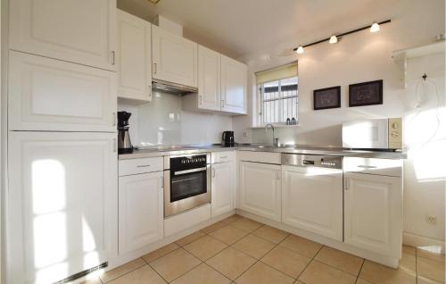 a white kitchen with white cabinets and appliances at Søhøjlandet in Gjern