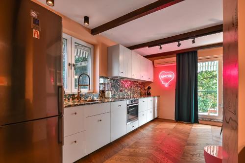 una cucina con armadietti bianchi e parete rossa di Lozenetz Gem: Cozy 1-Bedroom Apartment in Sofia a Sofia