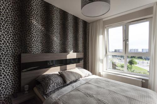 a bedroom with a bed and a large window at Apartament Bialystok in Białystok