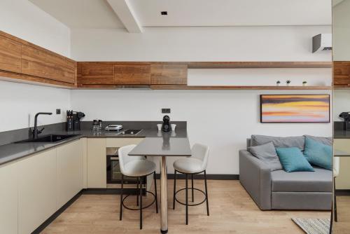 a kitchen and living room with a table and a couch at Bayview Hills Luxury Residences in Tivat
