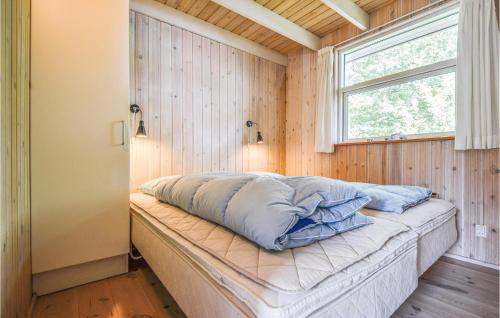 a bed in a room with a window at Awesome Home In Ebeltoft With 4 Bedrooms, Sauna And Wifi in Ebeltoft