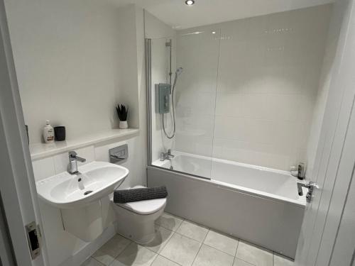 y baño con lavabo, aseo y ducha. en Salford Townhouse 3 BR Home en Mánchester