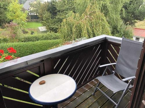 a table and a chair sitting on a balcony at Ferienwohnung Stockrose in Lohme