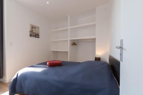 een slaapkamer met een blauw bed en witte muren bij LE BISTROT 203 - Tout équipé - WIFI & TV in Saint-Chamond