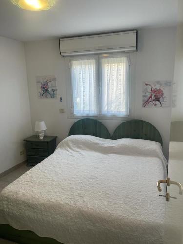 une chambre avec un lit blanc et une fenêtre dans l'établissement Appartement 2 pièces-4 personnes, à Roquebrune-Cap-Martin