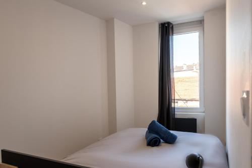 - une chambre avec un lit doté d'un oreiller bleu dans l'établissement Le Moonlight 204 - Machine à laver - Places gratuites, à Saint-Chamond