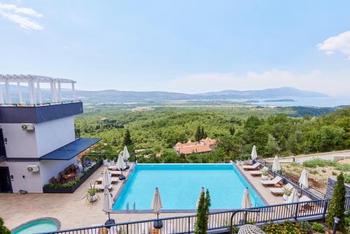 uma vista para a piscina num resort com cadeiras e guarda-sóis em Bayview Hills Luxury Residences em Tivat