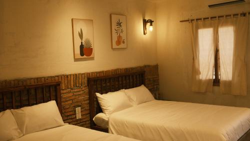 a bedroom with two beds and a window at Vũ House Phú Yên- Boutique Room & Breakfast in Tuy Hoa