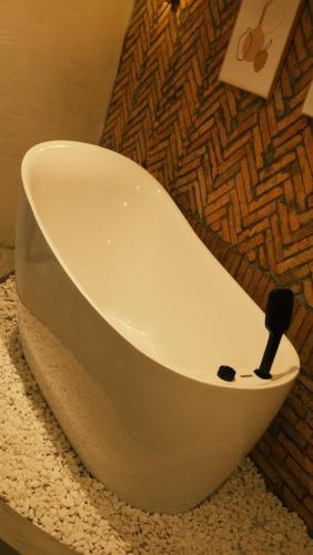 a white bath tub sitting on a counter in a bathroom at Vũ House Phú Yên- Boutique Room & Breakfast in Tuy Hoa