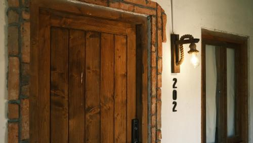 a wooden door in the corner of a room at Vũ House Phú Yên- Boutique Room & Breakfast in Tuy Hoa