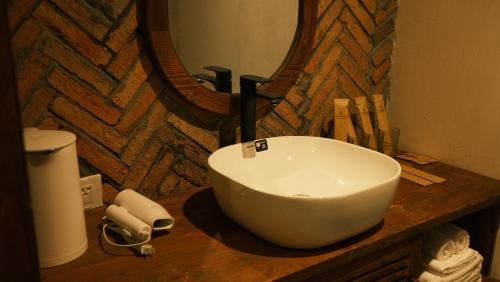 a white bowl sink on a wooden counter in a bathroom at Vũ House Phú Yên- Boutique Room & Breakfast in Tuy Hoa