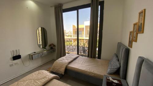 a bedroom with a bed and a window with a balcony at 2-Bedrooms TownHouse Villa dxb Gplus1 in Dubai
