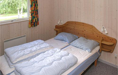 a bed in a room with a wooden head board at Stunning Home In Frvang With 3 Bedrooms, Wifi And Outdoor Swimming Pool in Fårvang