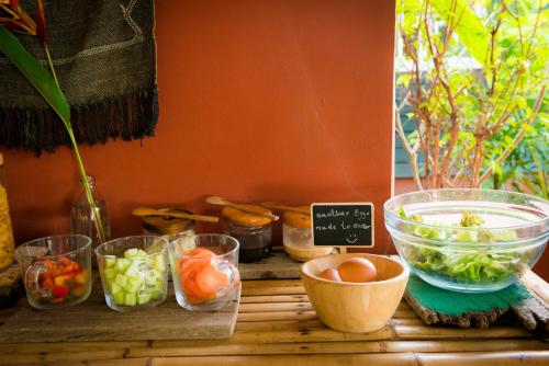 a table with bowls of vegetables and other food items at Oasis Yoga Bungalows in Ko Lanta