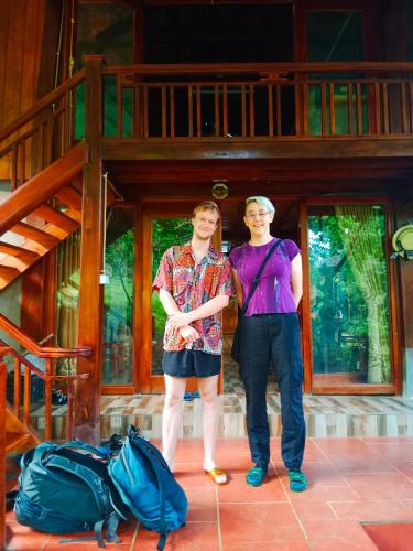 a man and a woman standing in front of a house at homestay phô núi suôi giang in Yên Bái