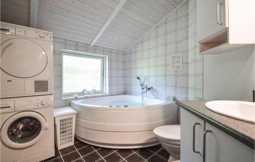 a bathroom with a tub and a toilet and a sink at Nice Home In Give With 3 Bedrooms, Sauna And Wifi in Lindet