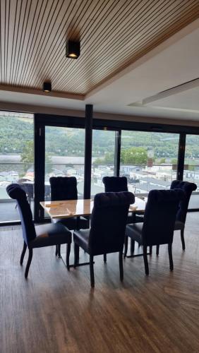 comedor con mesa y sillas y ventana grande en Loch Earn Holiday Home, en St Fillans