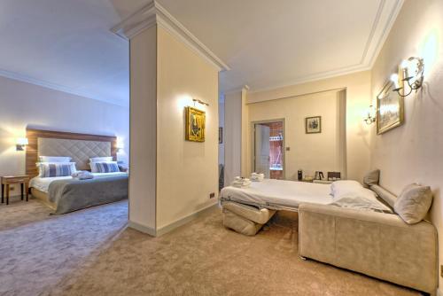 a large room with two beds and a couch at Westminster Hotel & Spa Nice in Nice