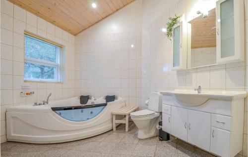 a bathroom with a tub and a toilet and a sink at Stunning Home In Ebeltoft With Kitchen in Øksenmølle