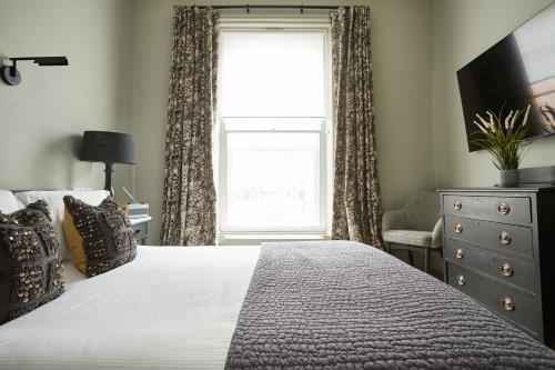 a bedroom with a large bed and a window at The King's Arms in Dorchester