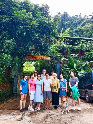 a group of people posing for a picture with a dog at homestay phô núi suôi giang in Yên Bái
