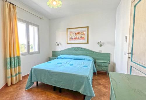 Un dormitorio con una cama verde y una ventana. en Relaxing Le Residenze del Maria Rosaria num2215, en Orosei