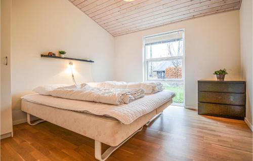 エーベルトフトにあるNice Home In Ebeltoft With 3 Bedrooms, Sauna And Wifiのベッドルーム1室(ベッド1台、ドレッサー、窓付)