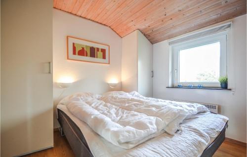 a bed in a room with a wooden ceiling at Amazing Home In Ebeltoft With 4 Bedrooms, Sauna And Wifi in Ebeltoft