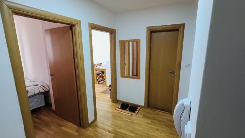 un couloir avec deux portes et une paire de chaussures dans l'établissement Felix Apartment Istocno Sarajevo, à Vranješ
