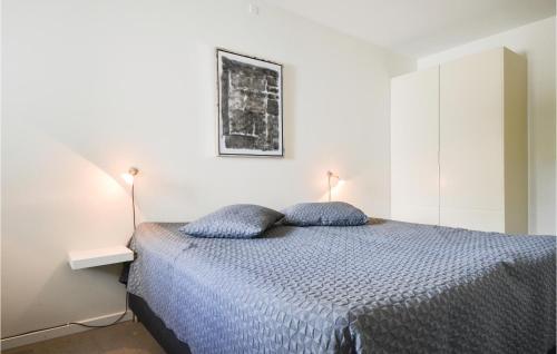 a bedroom with a bed with two blue pillows at Amazing Apartment In Ebeltoft With House Sea View in Ebeltoft