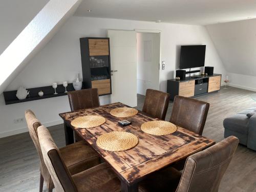 uma sala de jantar com uma mesa de madeira e cadeiras em Ferienwohnung, schön & modern, Strand/ -Grimmershörnbucht em Cuxhaven