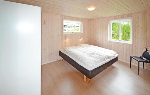 HjarbækにあるBeautiful Home In Lgstrup With 4 Bedrooms And Wifiのベッドルーム1室(ベッド1台、テーブル、窓2つ付)
