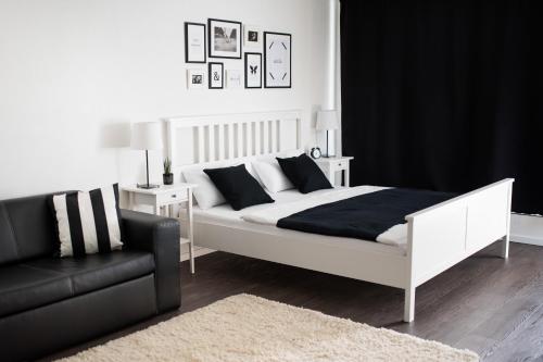 a bedroom with a white bed and a black couch at KELLER APARTMENT in Sulz am Neckar
