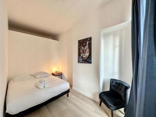 ein Schlafzimmer mit einem Bett und einem schwarzen Stuhl in der Unterkunft Cosy appart Lyon Part Dieu Félix 2 in Lyon