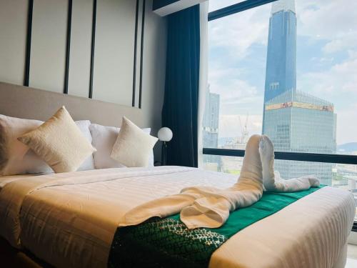 a woman laying on a bed in front of a window at The Axon Suites Bukit Bintang By Cozy Stay in Kuala Lumpur
