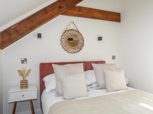 a bedroom with a bed and a mirror on the wall at The Stables in Beaumaris